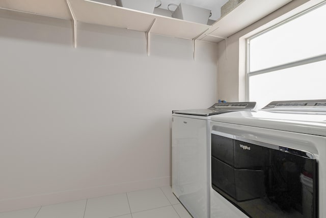 clothes washing area featuring washing machine and dryer and light tile patterned floors