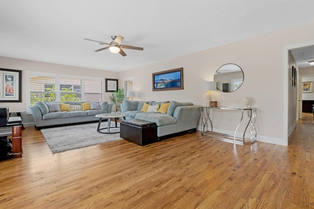 living room with light wood-type flooring and ceiling fan