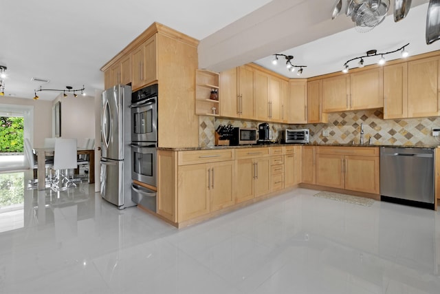 kitchen with sink, tasteful backsplash, light brown cabinets, stainless steel appliances, and light stone countertops