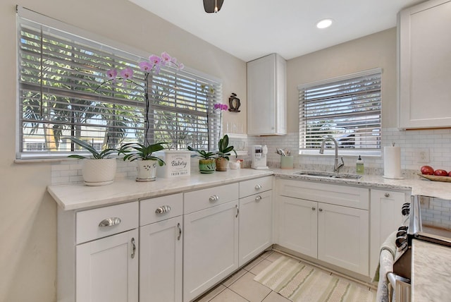 kitchen with white cabinets, light tile patterned floors, and sink