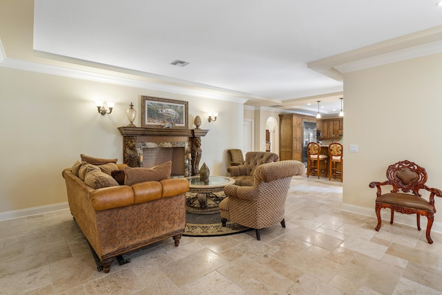 living room featuring crown molding, a high end fireplace, and a tray ceiling