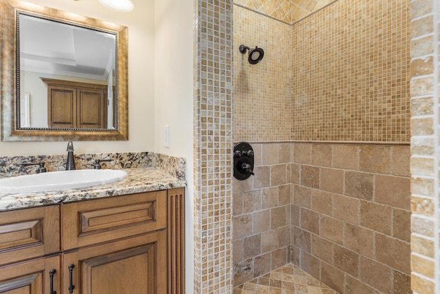 bathroom with tiled shower and vanity