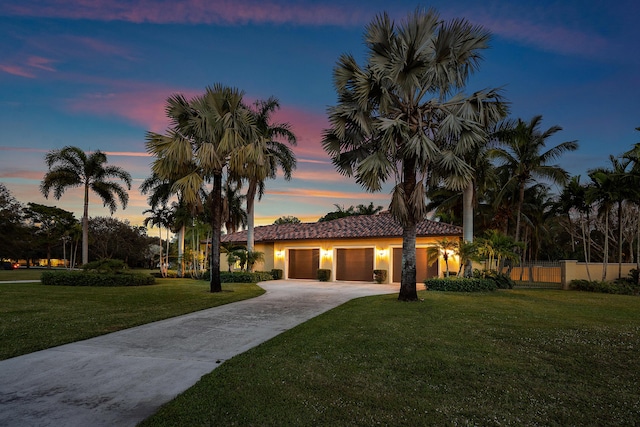 mediterranean / spanish-style house featuring a garage and a lawn