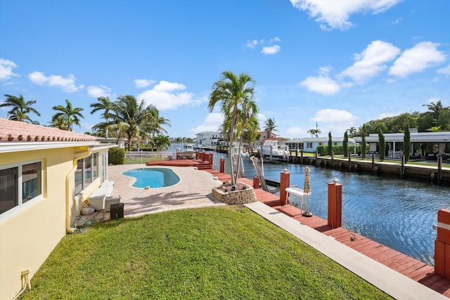 view of pool featuring a yard, a dock, a water view, and a patio