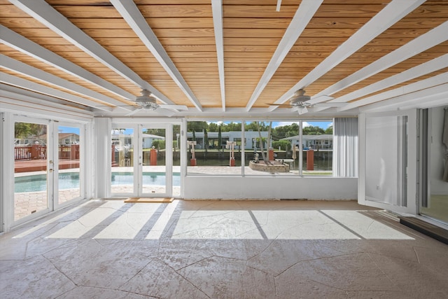 unfurnished sunroom featuring ceiling fan and french doors