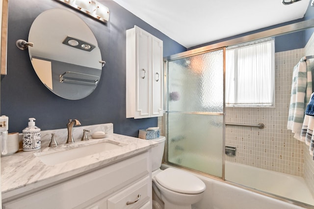 full bathroom with vanity, toilet, and enclosed tub / shower combo