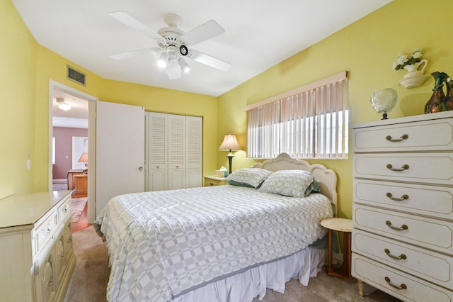 bedroom featuring ceiling fan, light carpet, and a closet