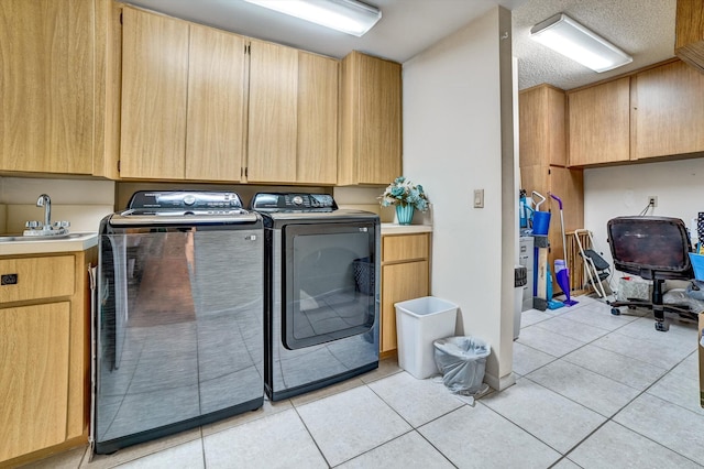 clothes washing area with cabinets, light tile patterned floors, separate washer and dryer, and sink