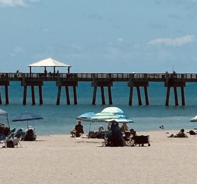 dock area with a water view and a view of the beach