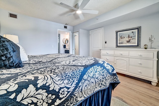 bedroom featuring a textured ceiling, light hardwood / wood-style floors, and ceiling fan