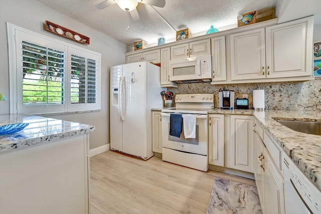 kitchen with white appliances, ceiling fan, a textured ceiling, tasteful backsplash, and light stone counters