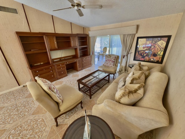 living room with lofted ceiling, ceiling fan, and a textured ceiling