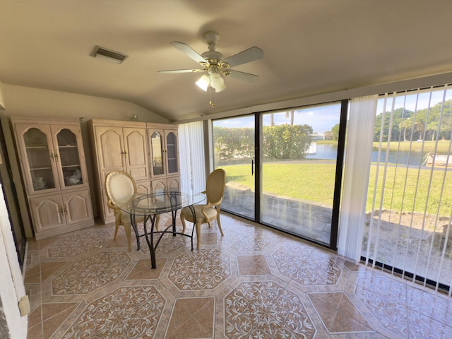 sunroom with ceiling fan, plenty of natural light, and a water view