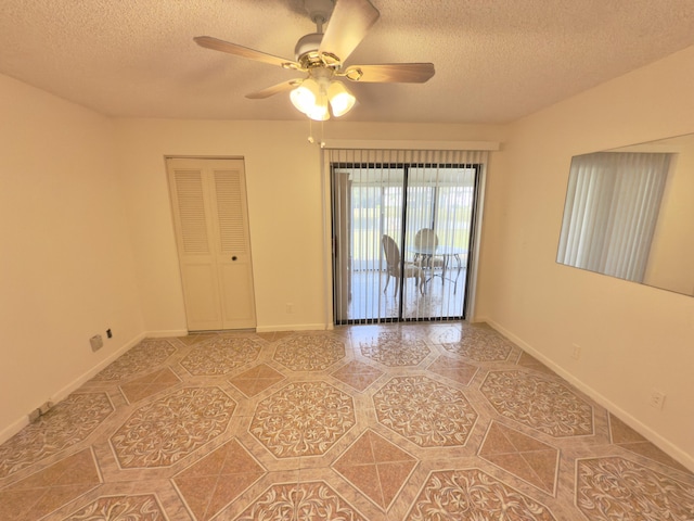 empty room with ceiling fan and a textured ceiling