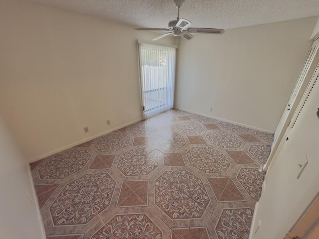 empty room featuring ceiling fan and a textured ceiling