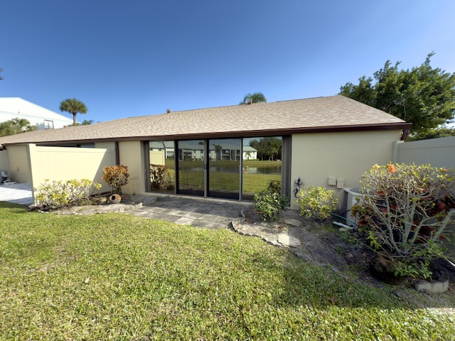 rear view of house featuring a yard