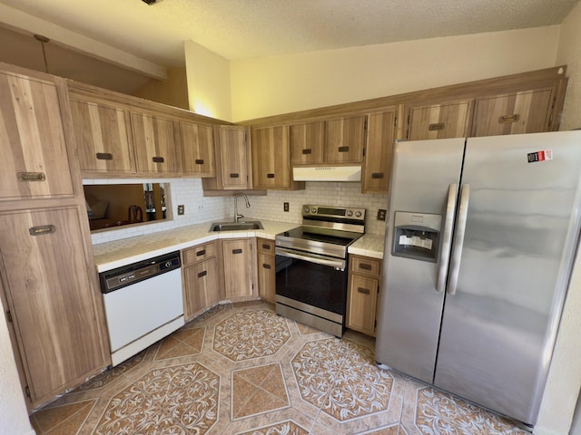 kitchen with appliances with stainless steel finishes, tasteful backsplash, lofted ceiling, and sink