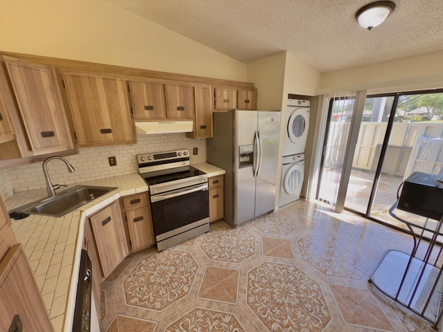 kitchen featuring stacked washer and clothes dryer, sink, tasteful backsplash, tile counters, and stainless steel appliances