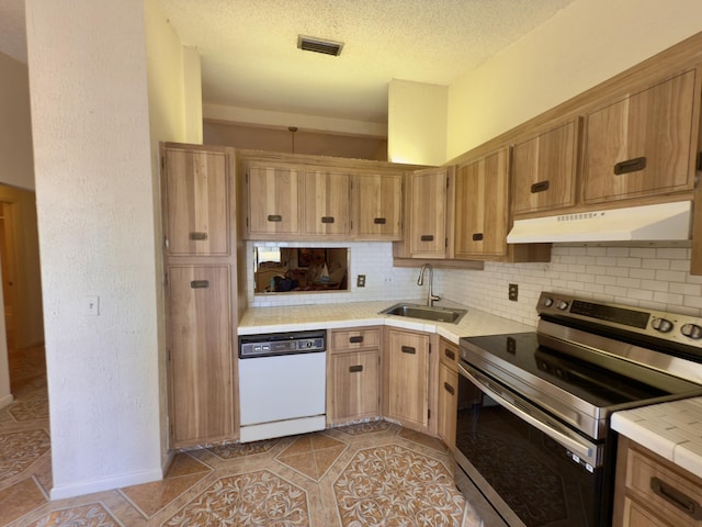 kitchen with tasteful backsplash, sink, light tile patterned floors, dishwasher, and stainless steel range with electric cooktop