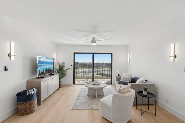 living room featuring light hardwood / wood-style flooring and ceiling fan