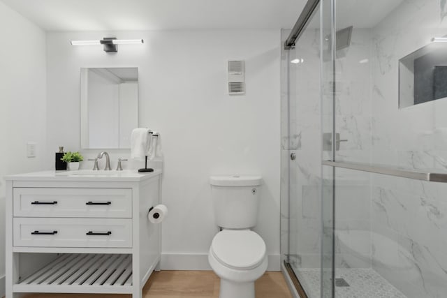 bathroom with vanity, toilet, and an enclosed shower