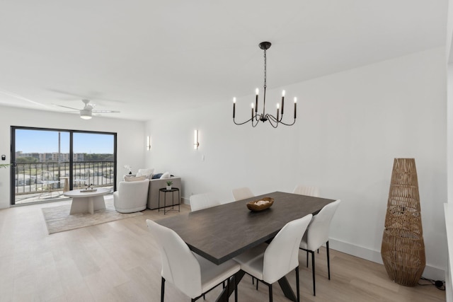 dining room featuring light wood-type flooring and ceiling fan with notable chandelier