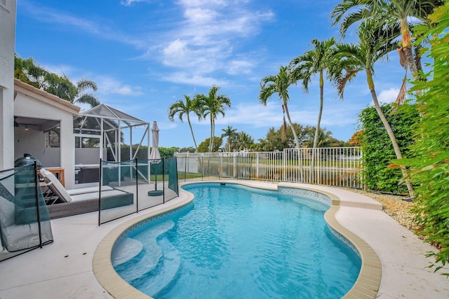 view of swimming pool featuring a lanai and a patio