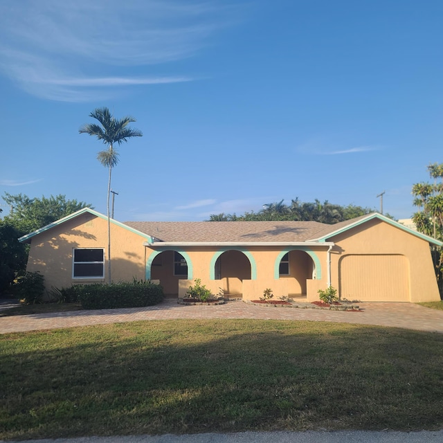 ranch-style house with a front yard and a garage