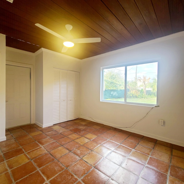 unfurnished bedroom with wooden ceiling, a closet, ceiling fan, and crown molding