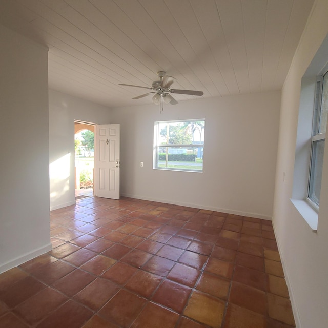 empty room with dark tile patterned flooring and ceiling fan