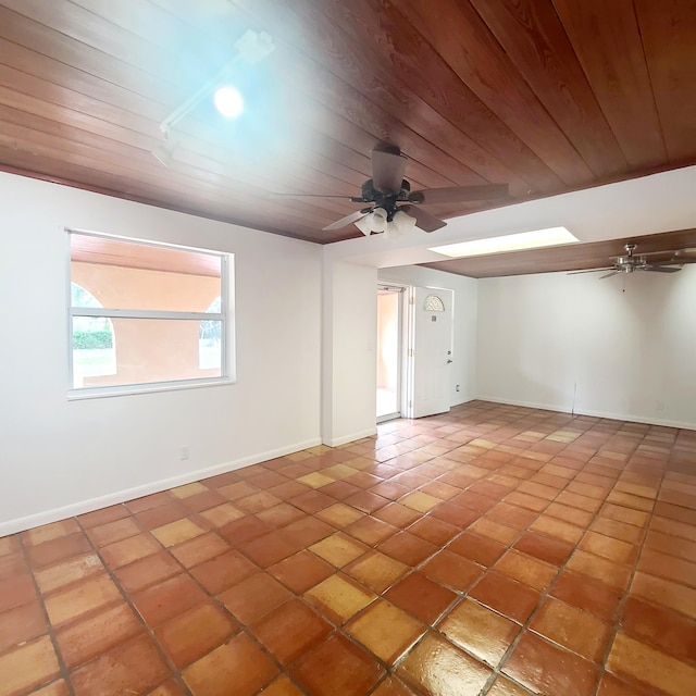 tiled empty room featuring ceiling fan and wood ceiling