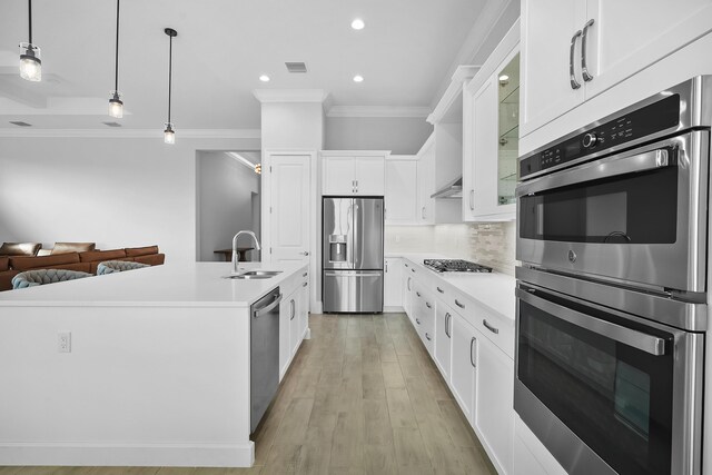 kitchen with a kitchen island with sink, sink, white cabinets, and appliances with stainless steel finishes