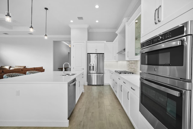 kitchen featuring stainless steel appliances, a sink, visible vents, light countertops, and decorative backsplash