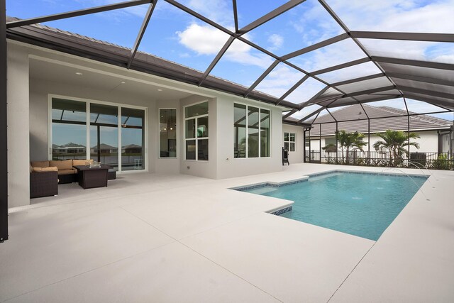 view of swimming pool featuring pool water feature, a yard, a patio area, and a lanai