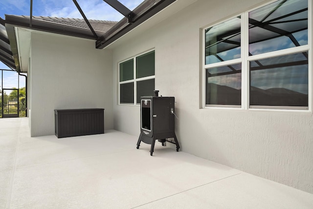 view of patio featuring glass enclosure