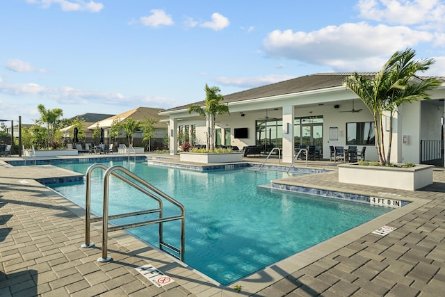 pool with a patio area, fence, and ceiling fan