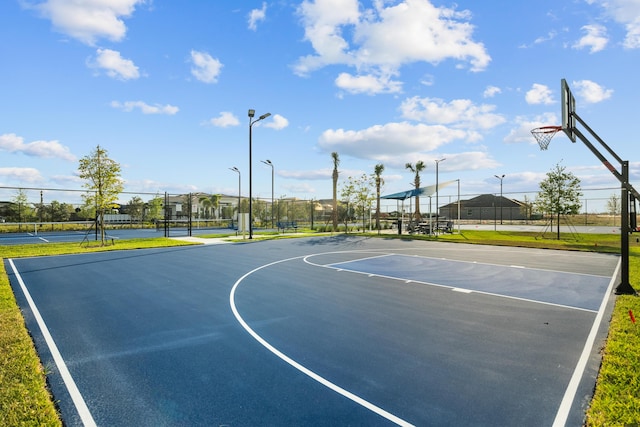 view of sport court with a tennis court, community basketball court, and fence