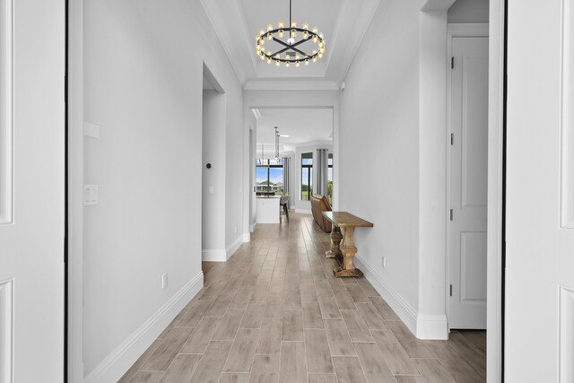 hallway with a chandelier and crown molding