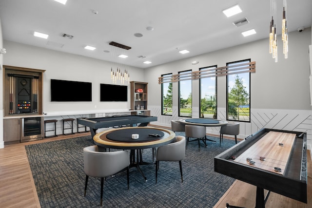 playroom with light wood-style floors, beverage cooler, and visible vents