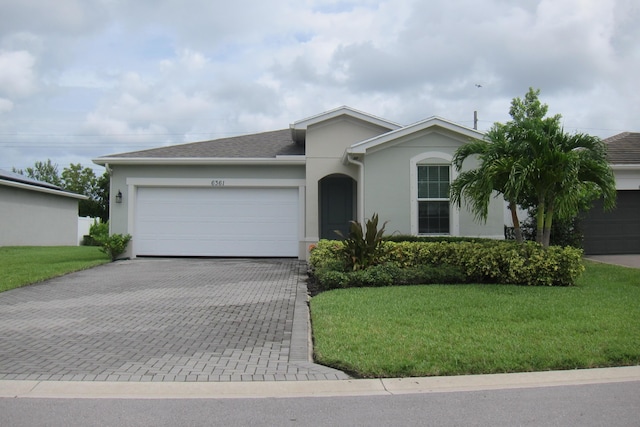 ranch-style house featuring a garage and a front yard