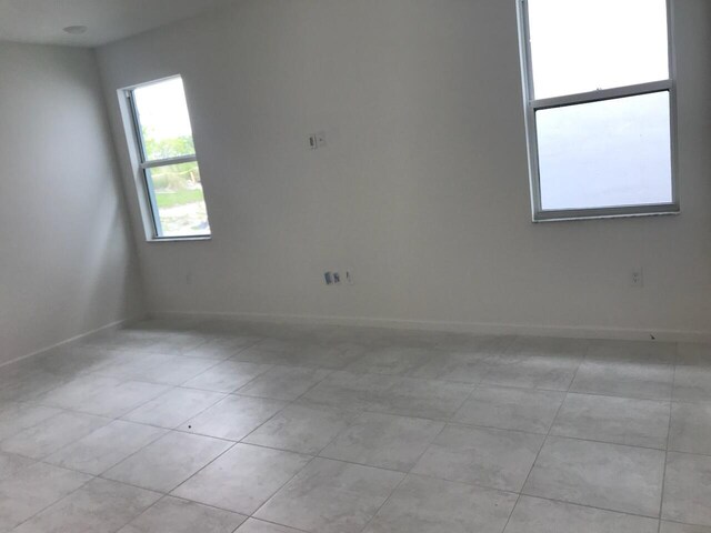 laundry area with washing machine and dryer and light tile patterned floors