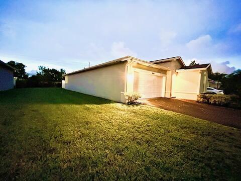 view of side of property featuring a lawn and a garage