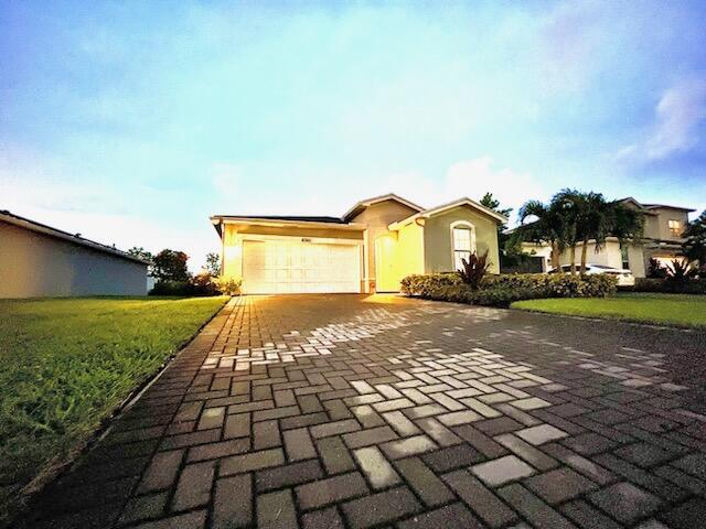 ranch-style home featuring a front lawn and a garage