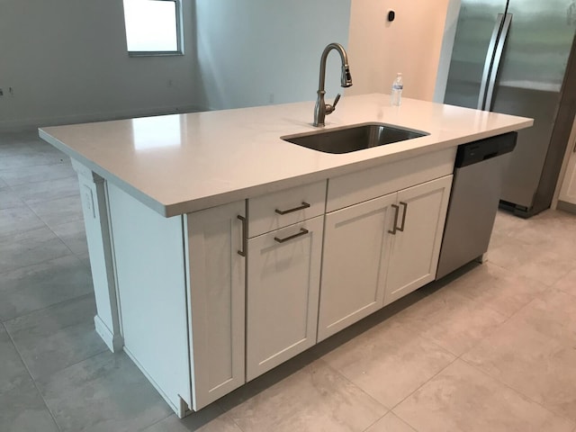 kitchen featuring white cabinetry, sink, stainless steel appliances, and a center island with sink