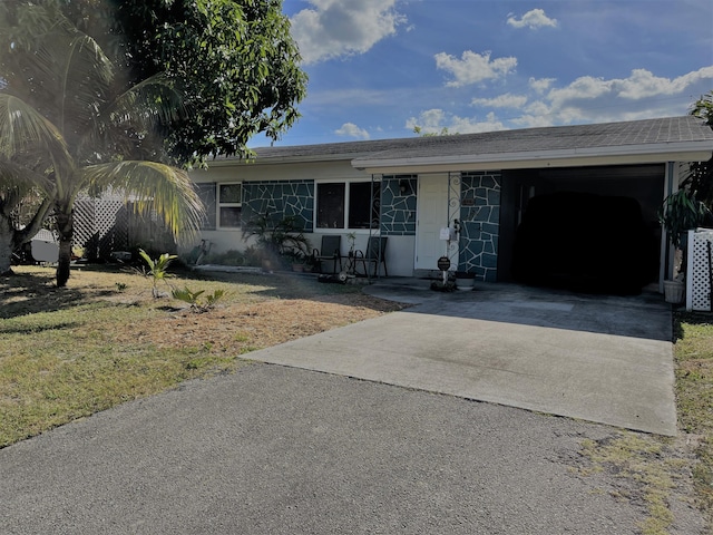 ranch-style house featuring a carport, central AC unit, and a front lawn