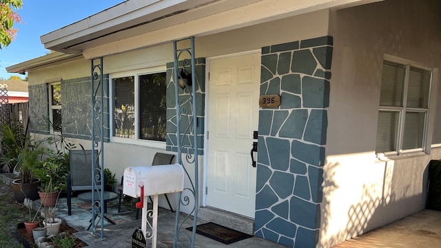 doorway to property featuring stucco siding