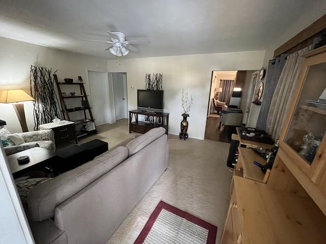 carpeted living room with ceiling fan