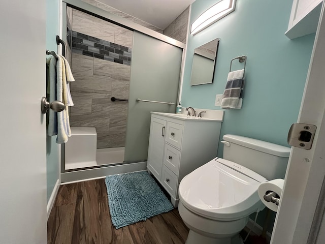 bathroom with vanity, hardwood / wood-style floors, an enclosed shower, and toilet