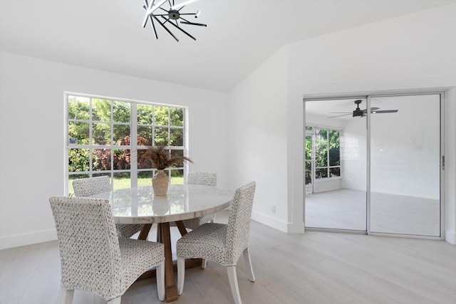 dining space featuring light hardwood / wood-style flooring, a healthy amount of sunlight, and ceiling fan with notable chandelier