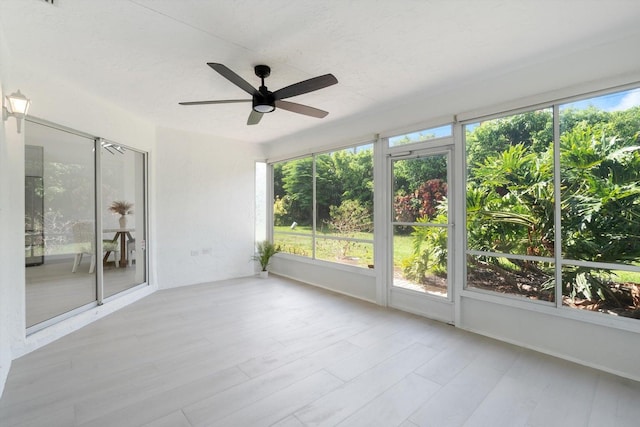 unfurnished sunroom with ceiling fan